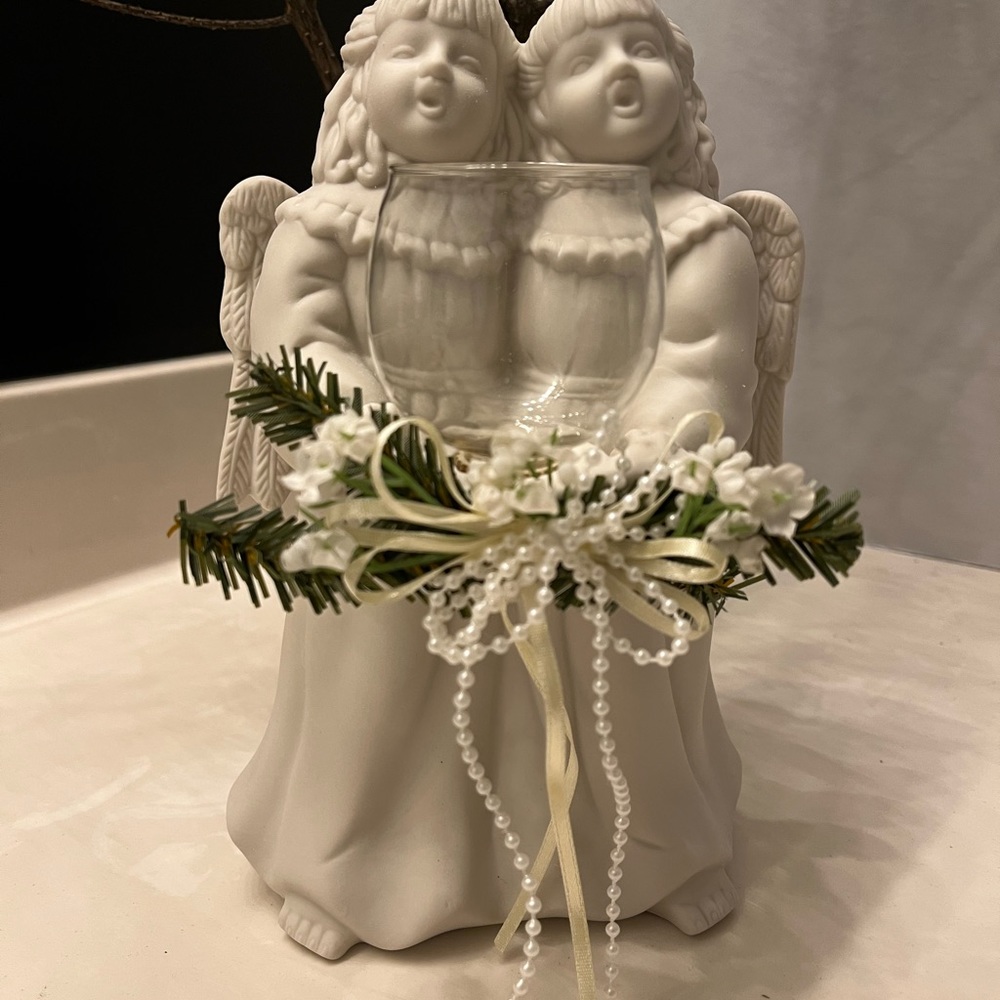 The Candle Holder is made of White Porcelain Bisque and features angels in song